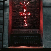 red cactus jack neon sign hanging on bar wall