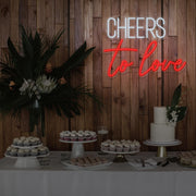 red cheers to love neon sign hanging above dessert table