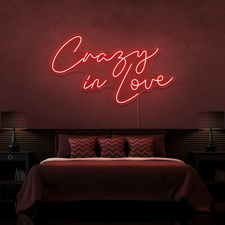red crazy in love neon sign hanging on bedroom wall