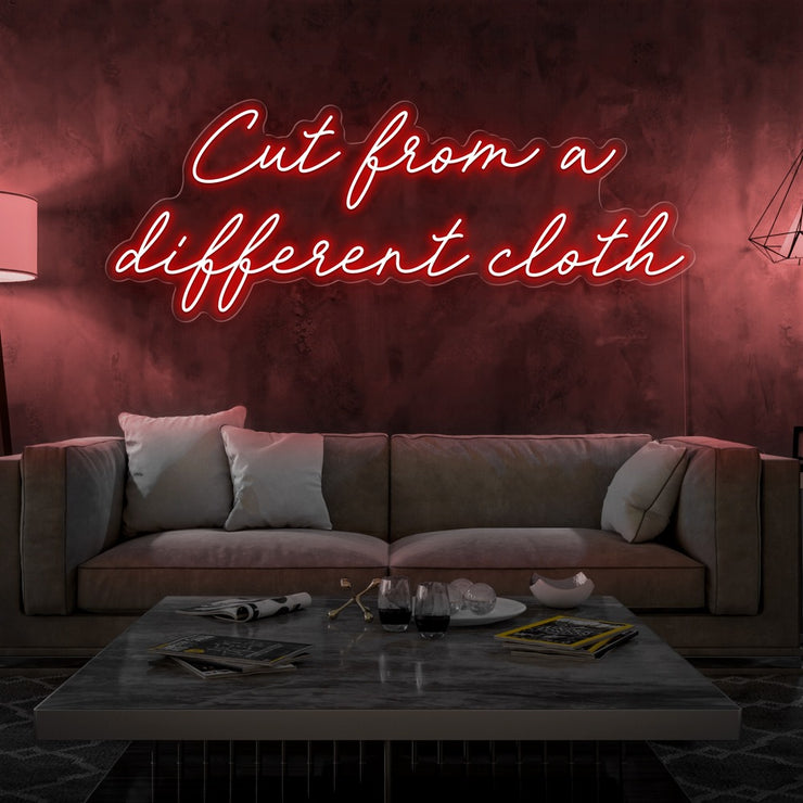 red cut from a different cloth neon sign hanging on living room wall