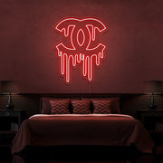 red dripping chanel neon sign hanging on bedroom wall
