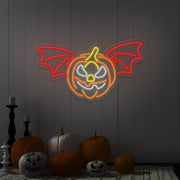 red flying pumpkin neon sign hanging on wall above pumpkins