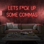 red lets fuck up commas neon sign hanging on living room wall
