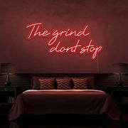 red the grind dont stop neon sign hanging on bedroom wall