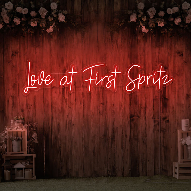red love at first spritz neon sign hanging on timber wall