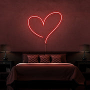 red love heart neon sign hanging on bedroom wall