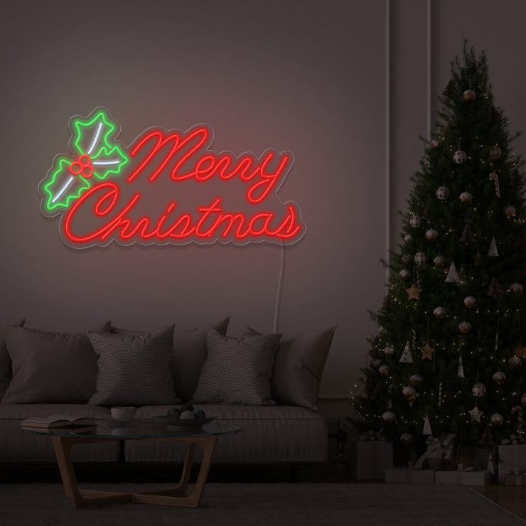 red merry chirstmas mistletoe neon sign hanging above couch next to christmas tree