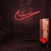 red nike swoosh neon sign hanging on gym wall