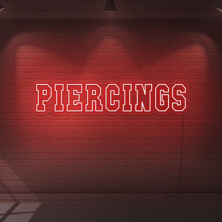 red piercings neon sign hanging on wall