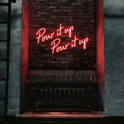 red pour it up neon sign hanging on bar wall