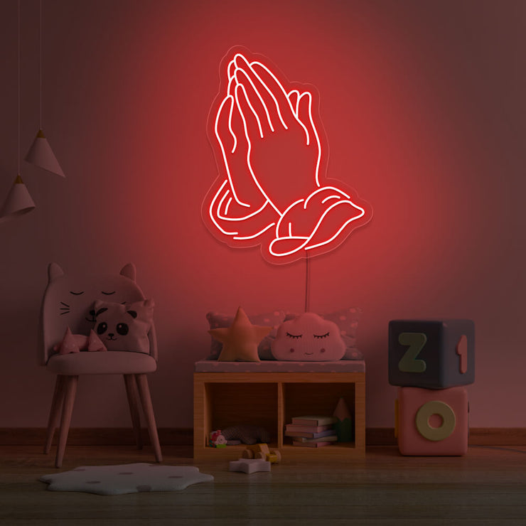 red praying hands neon sign hanging on kids bedroom wall