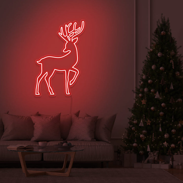 red reindeer neon sign hanging on living room wall next to christmas tree