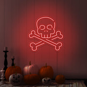 red skull bones neon sign with pumpkins on floor