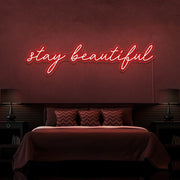 red stay beautiful neon sign hanging on bedroom wall