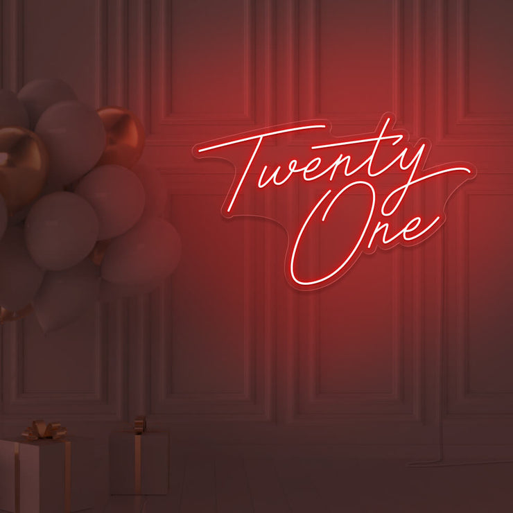 red  twenty one neon sign hanging on wall with balloons