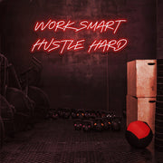 red work smart hustle hard neon sign hanging on gym wall