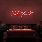 red xoxo neon sign hanging on bedroom wall