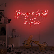 red young wild and free neon sign hanging on kids bedroom wall