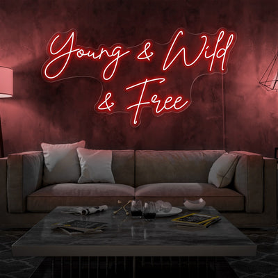 red young and wild and free neon sign hanging on living room wall