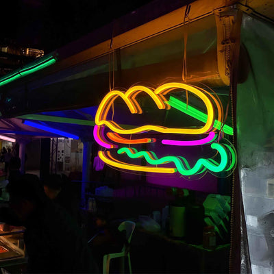 sandwich neon sign hanging on tent at outdoor event