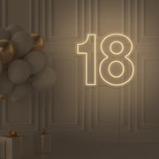 warm white 18 neon sign hanging on wall with balloons