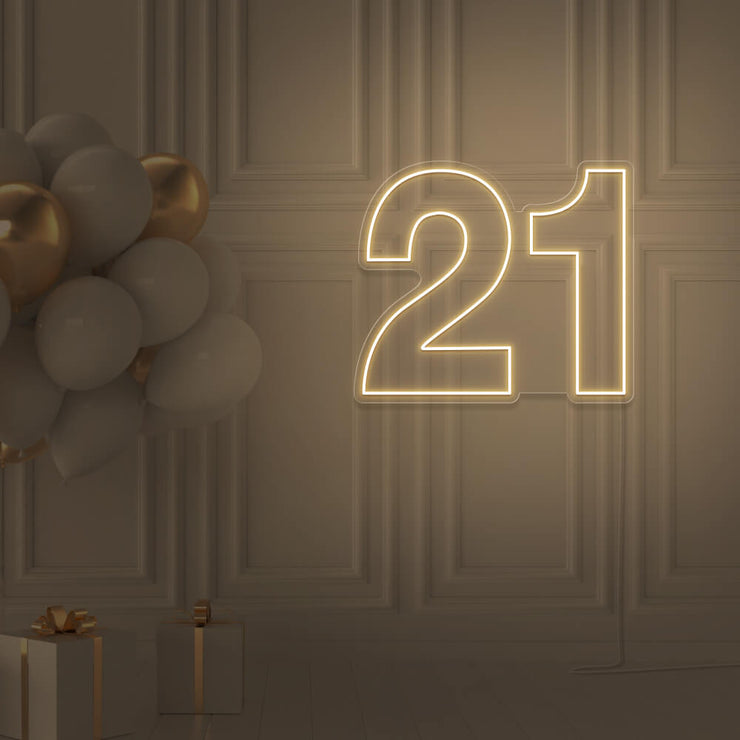 warm white  21 neon sign hanging on wall with balloons