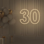 warm white 30 neon sign hanging on wall with balloons