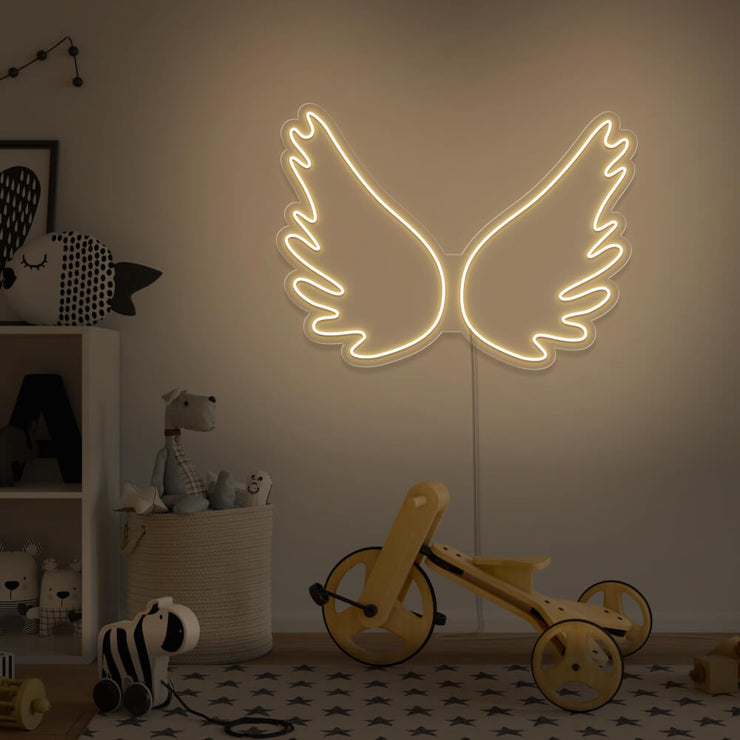 warm white angel wings neon sign hanging on kids bedroom wall