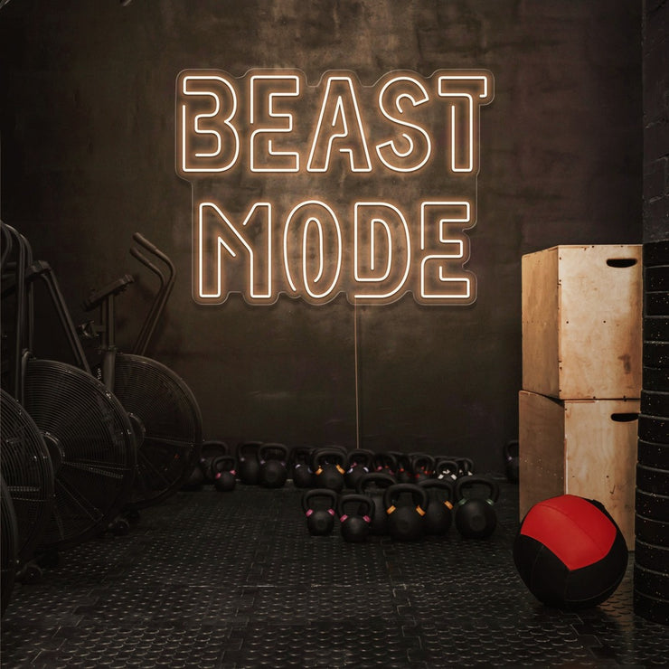 warm white beast mode neon sign hanging on gym wall