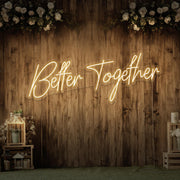 warm white better together neon sign hanging on timber wall