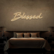 warm white blessed neon sign hanging on bedroom wall