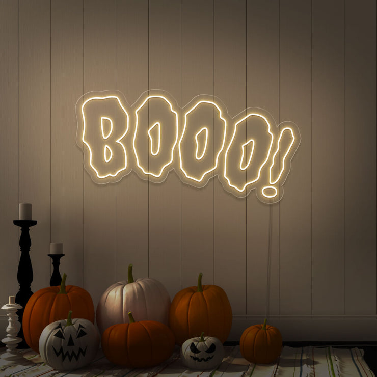 warm white boo neon sign with halloween pumpkins on floor