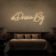 warm white dream big neon sign hanging on bedroom wall