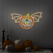 warm white flying pumpkin neon sign hanging on wall above pumpkins