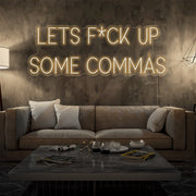 warm white lets fuck up commas neon sign hanging on living room wall