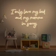 warm white I only love my bed and my momma I'm sorry neon sign hanging on kids wall