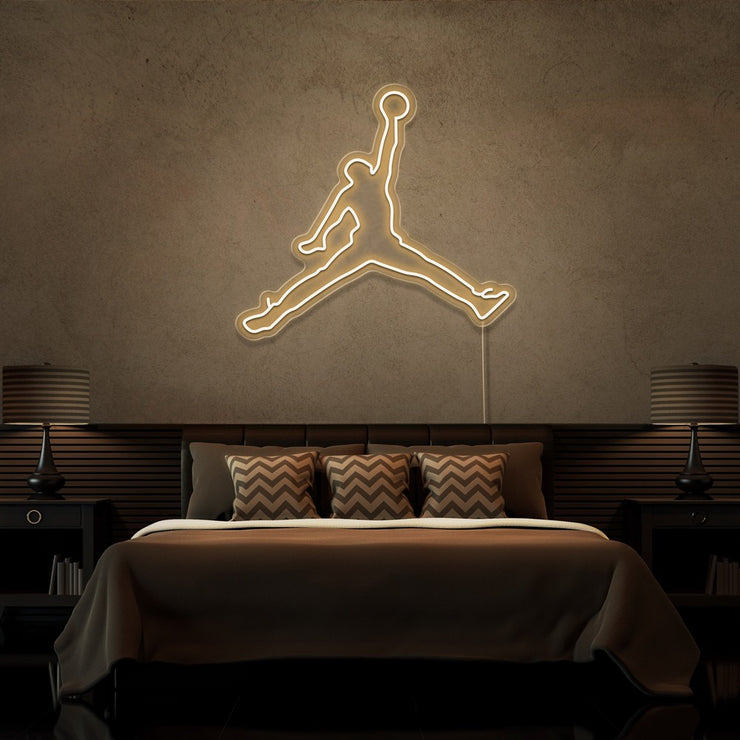warm white jordan jumpman neon sign hanging on bedroom wall