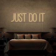 warm white just do it neon sign hanging on bedroom wall