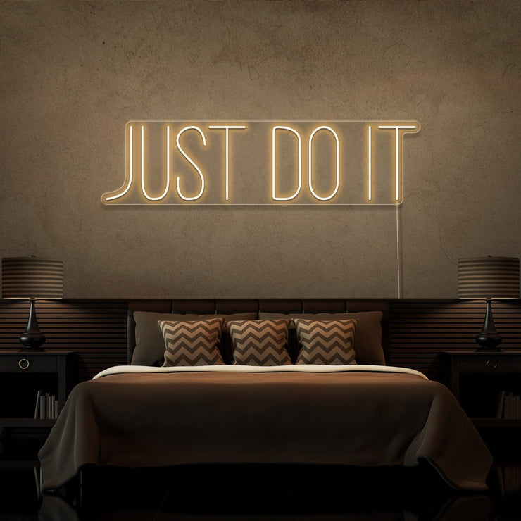 warm white just do it neon sign hanging on bedroom wall