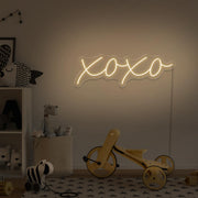 warm white xoxo neon sign hanging on kids bedroom wall