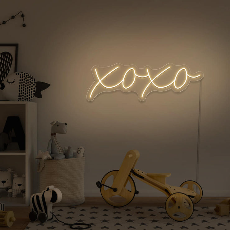 warm white xoxo neon sign hanging on kids bedroom wall
