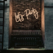 warm white lets party neon sign hanging on bar wall