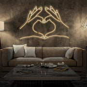 warm white love hands neon sign hanging on living room wall