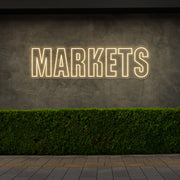 warm white markets neon sign hanging on outside wall