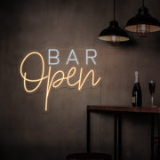 warm white open bar neon sign hanging on bar wall