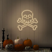 warm white skull bones neon sign with pumpkins on floor