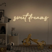 warm white sweet dreams neon sign hanging on kids bedroom wall