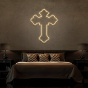 warm white tupac cross neon sign hanging on bedroom wall