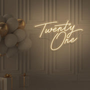 warm white  twenty one neon sign hanging on wall with balloons