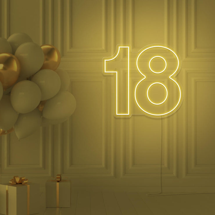 yellow 18 neon sign hanging on wall with balloons